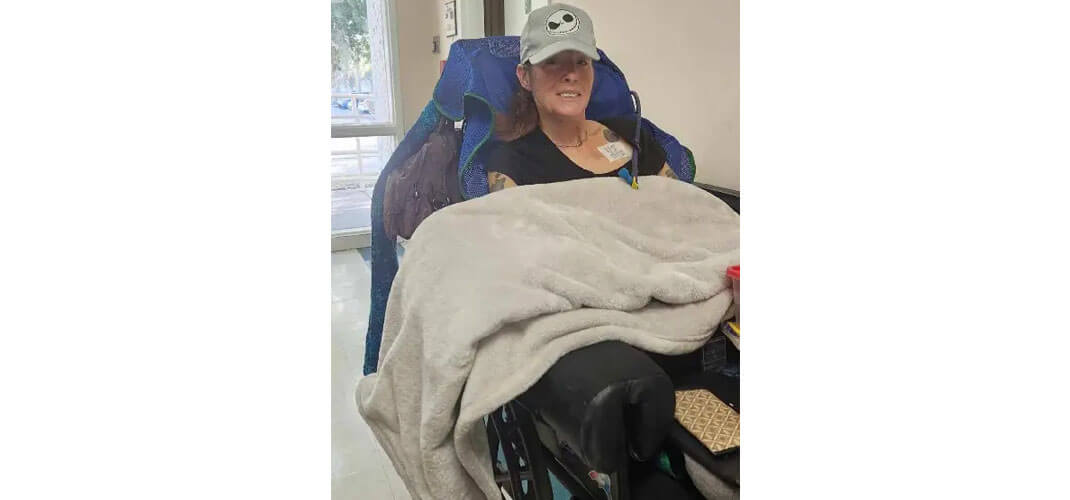 Jean in her power wheelchair with sip and puff system